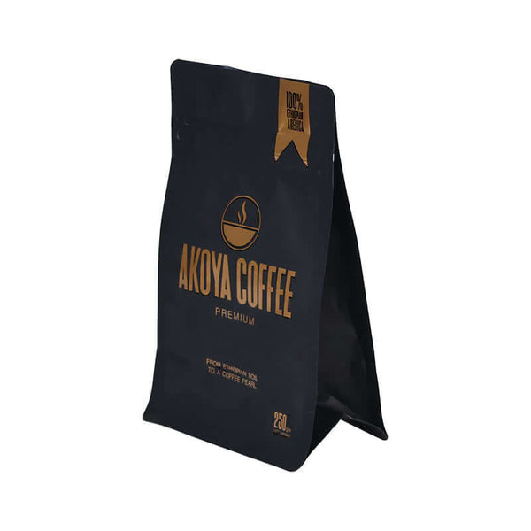 Premium matte black coffee bags with valve showing the one-way degassing component for professional coffee roasting.