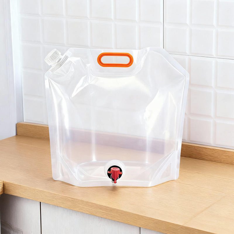 Transparent stand up BIB dispenser pouch with orange handle, top spout and bottom valve on counter